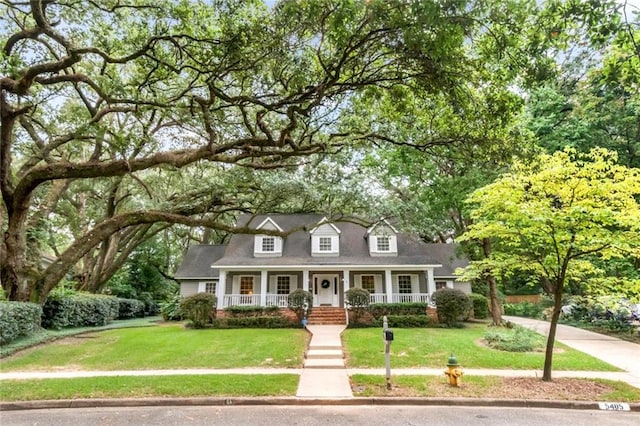 cape cod home featuring a porch and a front yard