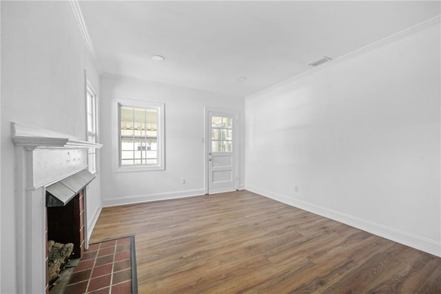 unfurnished living room with wood-type flooring and ornamental molding