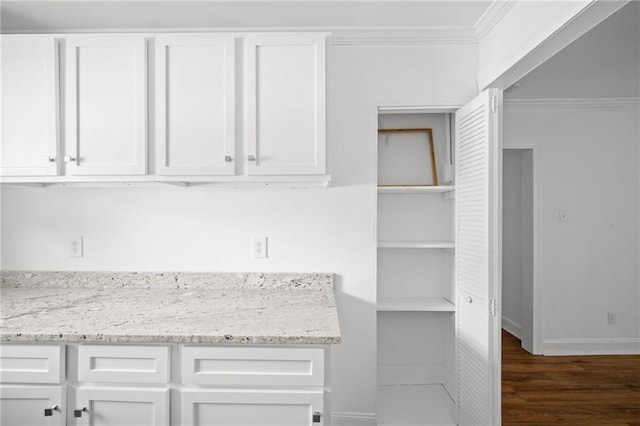 kitchen with white cabinetry, dark hardwood / wood-style floors, and light stone counters