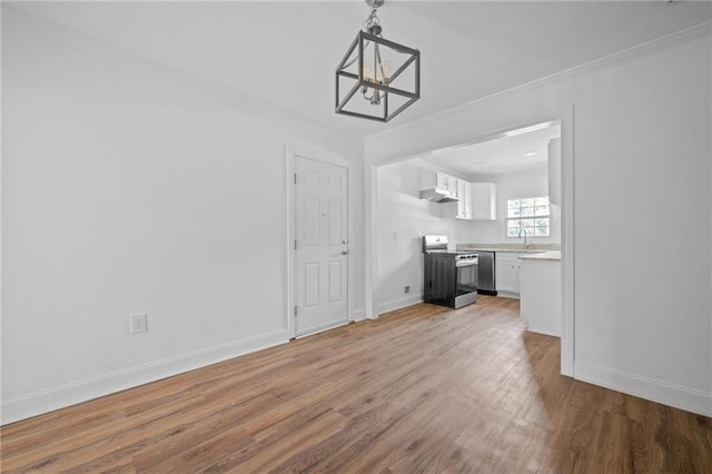 unfurnished living room with wood-type flooring, ornamental molding, and a chandelier