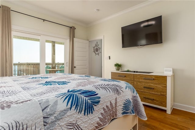 bedroom with access to exterior, baseboards, crown molding, and wood finished floors