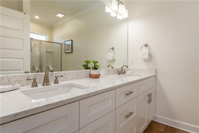 bathroom with crown molding, a sink, baseboards, and double vanity