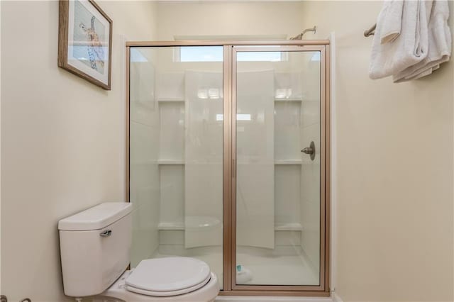 full bath featuring a shower stall and toilet
