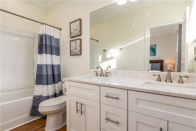 ensuite bathroom with double vanity, shower / tub combo, a sink, and wood finished floors