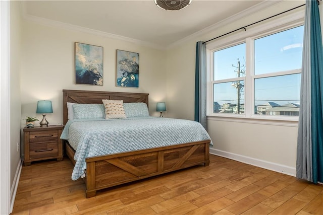 bedroom featuring light wood-type flooring, baseboards, and ornamental molding