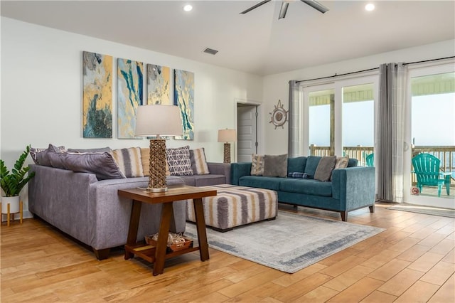 living room with vaulted ceiling, light wood-style flooring, visible vents, and recessed lighting