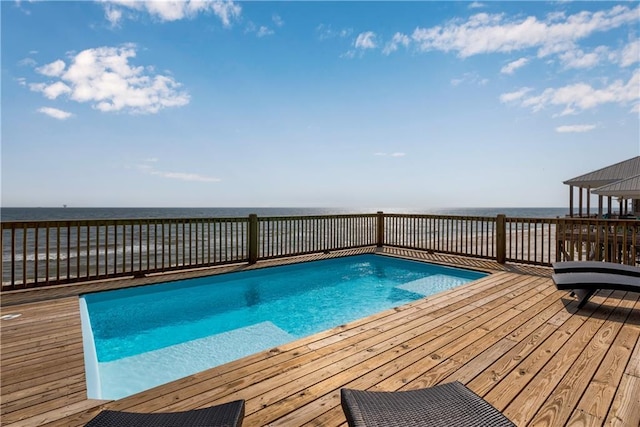 outdoor pool with a deck with water view