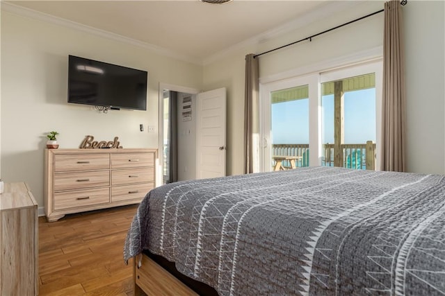 bedroom featuring access to exterior, crown molding, and wood finished floors