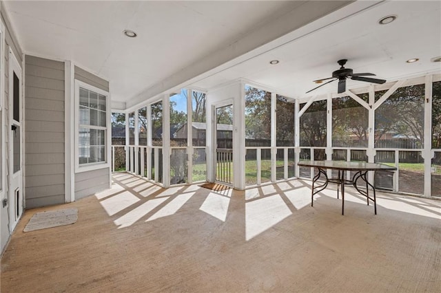 unfurnished sunroom featuring ceiling fan