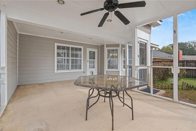 unfurnished sunroom featuring ceiling fan