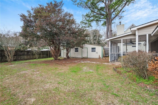 view of yard featuring a sunroom and ceiling fan