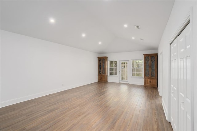 unfurnished bedroom with hardwood / wood-style floors, a closet, and vaulted ceiling