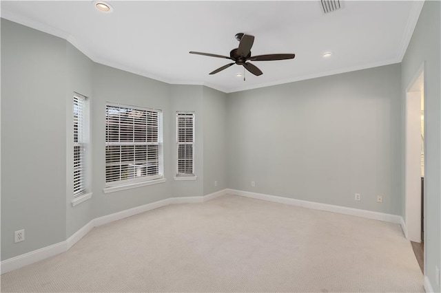 empty room featuring ceiling fan, light carpet, and crown molding