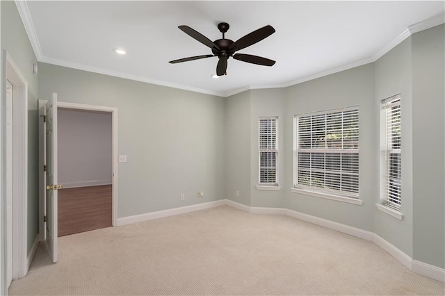 carpeted spare room featuring ceiling fan and ornamental molding