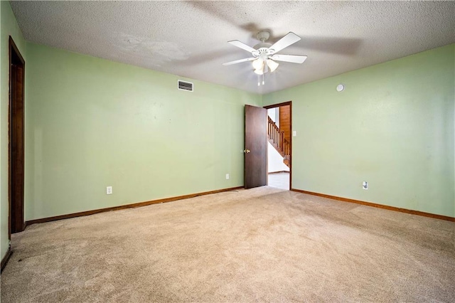 9731 Hamilton Creek Dr S, Mobile, AL 36695 - carpeted empty room featuring a ceiling fan, baseboards, stairway, and a textured ceiling