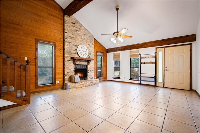 9731 Hamilton Creek Dr S, Mobile, AL 36695 - unfurnished living room featuring plenty of natural light, wood walls, ceiling fan, light tile patterned floors, and high vaulted ceiling