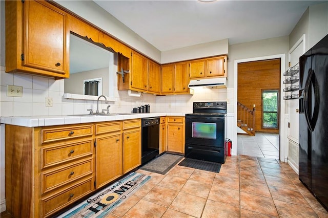9731 Hamilton Creek Dr S, Mobile, AL 36695 - kitchen featuring black appliances, under cabinet range hood, a sink, decorative backsplash, and brown cabinets