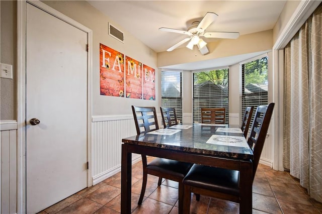 9731 Hamilton Creek Dr S, Mobile, AL 36695 - dining room featuring a wainscoted wall, a ceiling fan, and tile patterned floors