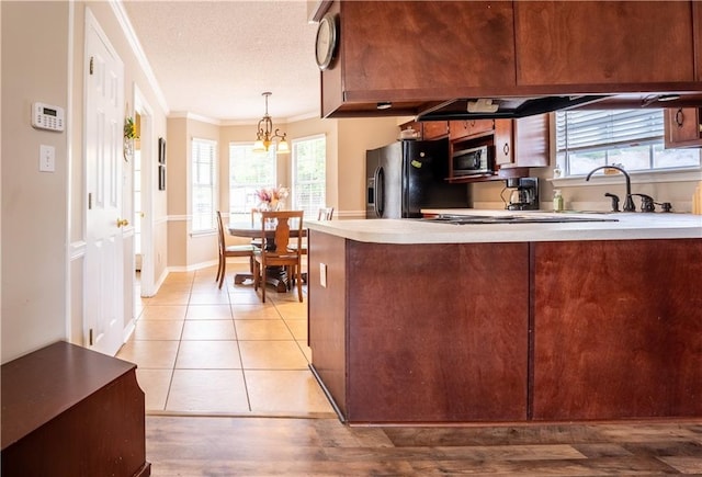 13330 Wages Ct, Mobile, AL 36695 - kitchen featuring stainless steel microwave, crown molding, black fridge, a peninsula, and light countertops