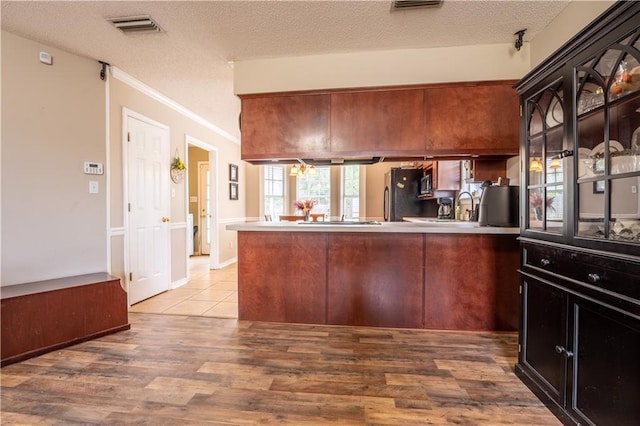 13330 Wages Ct, Mobile, AL 36695 - kitchen featuring a textured ceiling, a peninsula, wood finished floors, refrigerator, and crown molding