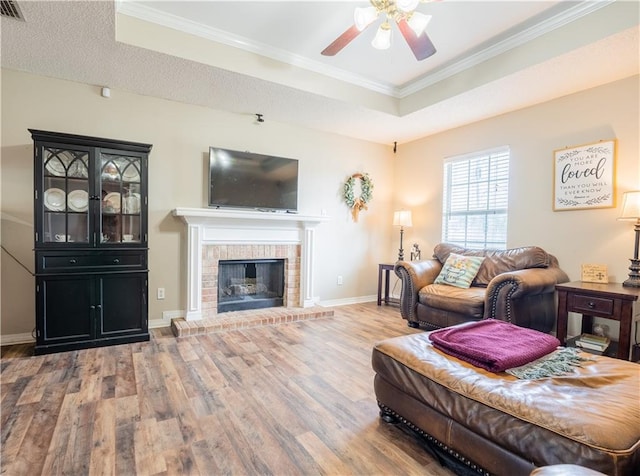 13330 Wages Ct, Mobile, AL 36695 - living area with a raised ceiling, wood finished floors, ceiling fan, ornamental molding, and a brick fireplace
