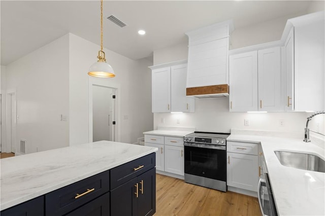 5305 Laurendine Rd, Theodore, AL 36582 - kitchen featuring stainless steel electric range, white cabinetry, hanging light fixtures, premium range hood, and light wood-style flooring