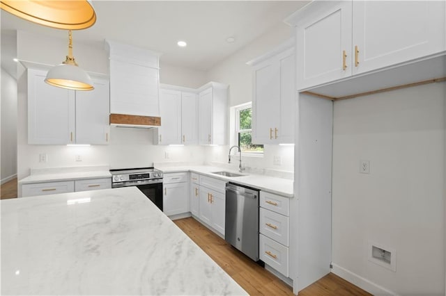5305 Laurendine Rd, Theodore, AL 36582 - kitchen featuring appliances with stainless steel finishes, light wood finished floors, white cabinets, light stone countertops, and recessed lighting