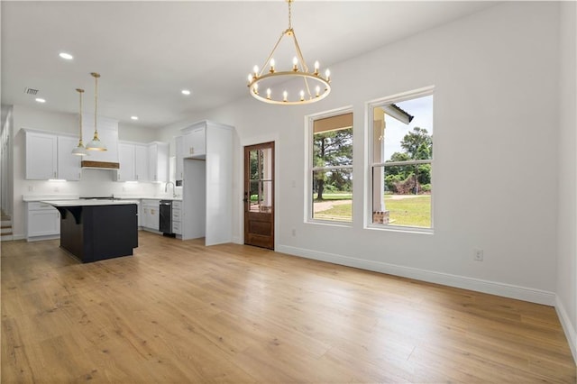5305 Laurendine Rd, Theodore, AL 36582 - kitchen featuring white cabinets, light wood-style floors, a chandelier, light countertops, and a breakfast bar area
