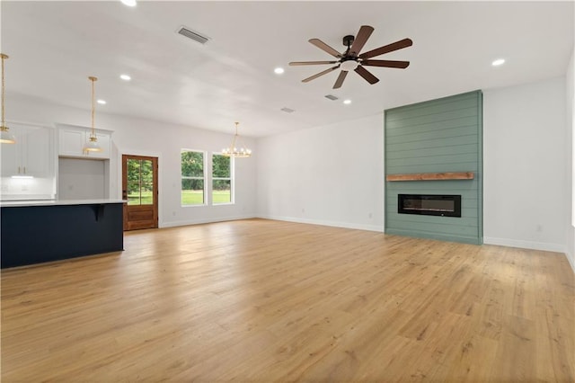 5305 Laurendine Rd, Theodore, AL 36582 - unfurnished living room with a fireplace, recessed lighting, light wood-type flooring, a ceiling fan, and a chandelier