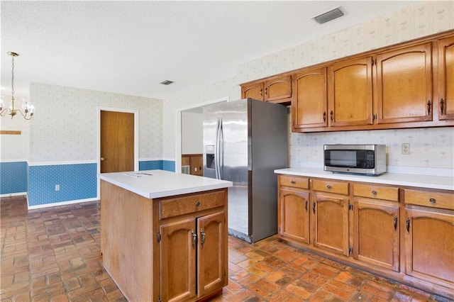 10437 Traci Dr, Semmes, AL 36575 - kitchen with appliances with stainless steel finishes, brown cabinetry, wainscoting, and wallpapered walls