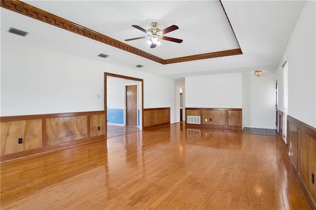 10437 Traci Dr, Semmes, AL 36575 - unfurnished room with ceiling fan, visible vents, wood finished floors, and a wainscoted wall