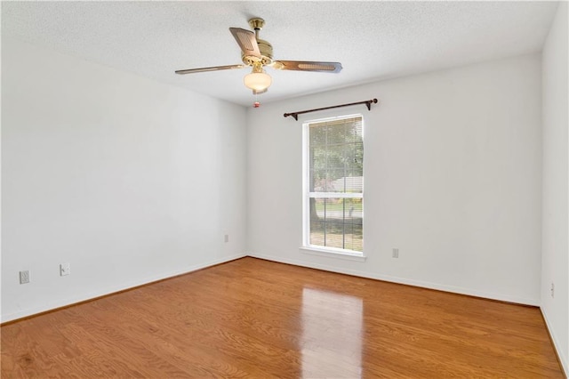 10437 Traci Dr, Semmes, AL 36575 - spare room with baseboards, a ceiling fan, a textured ceiling, and wood finished floors