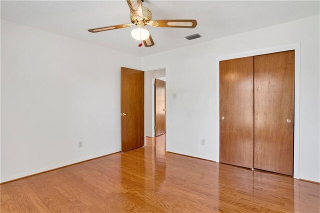 10437 Traci Dr, Semmes, AL 36575 - unfurnished bedroom with a ceiling fan, visible vents, wood finished floors, baseboards, and a closet
