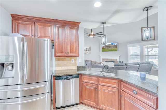 kitchen with pendant lighting, sink, stainless steel appliances, and stone counters