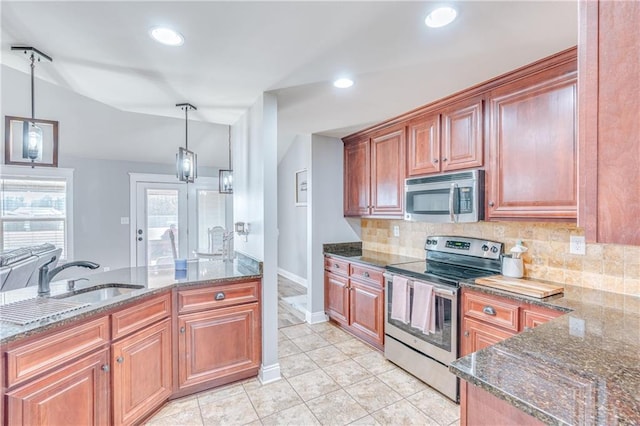 kitchen with hanging light fixtures, sink, dark stone counters, and appliances with stainless steel finishes