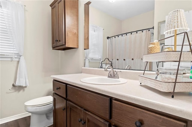 bathroom featuring vanity, wood-type flooring, and toilet