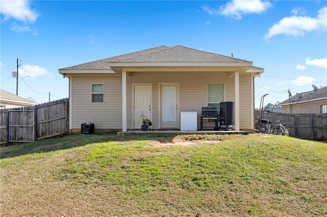 back of house featuring a lawn