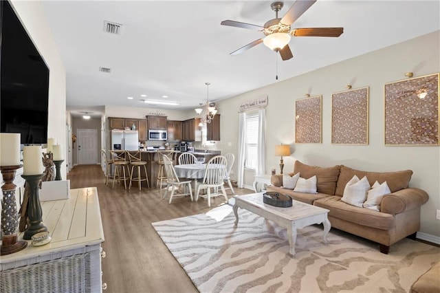 living room featuring ceiling fan and light hardwood / wood-style flooring