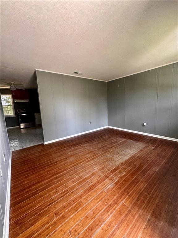 17080A Wayne Johnson Ln, Fairhope, AL 36532 - spare room with wood finished floors, baseboards, a ceiling fan, a fireplace, and a decorative wall