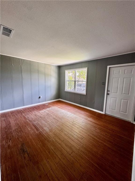 17080A Wayne Johnson Ln, Fairhope, AL 36532 - spare room with hardwood / wood-style flooring, a textured ceiling, a decorative wall, and baseboards