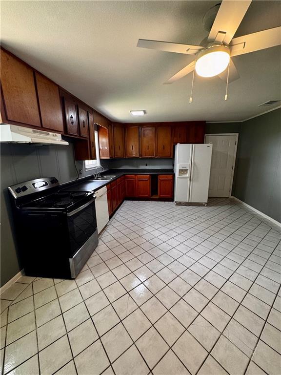 17080A Wayne Johnson Ln, Fairhope, AL 36532 - kitchen featuring white appliances, under cabinet range hood, dark countertops, and light tile patterned floors