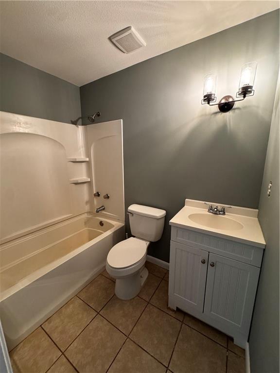 17080A Wayne Johnson Ln, Fairhope, AL 36532 - full bath with shower / bath combination, toilet, vanity, tile patterned floors, and a textured ceiling