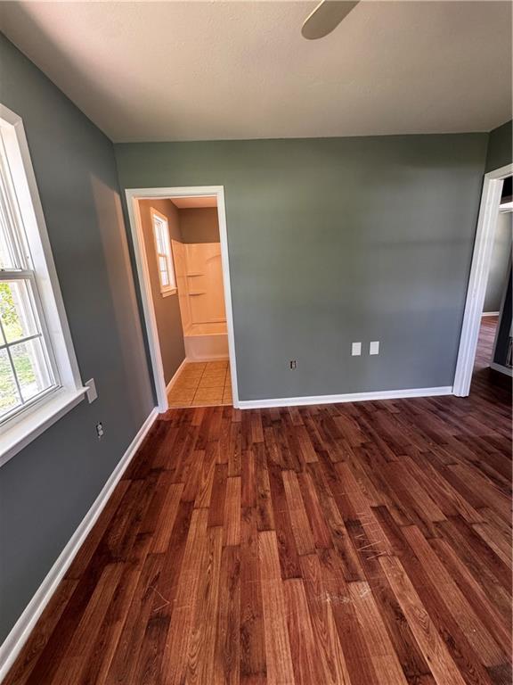 17080A Wayne Johnson Ln, Fairhope, AL 36532 - unfurnished room with dark wood-style flooring, plenty of natural light, baseboards, and ceiling fan