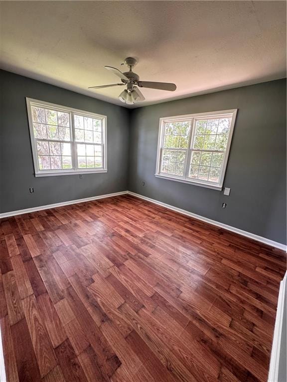 17080A Wayne Johnson Ln, Fairhope, AL 36532 - spare room featuring dark wood-style floors, healthy amount of natural light, and a ceiling fan