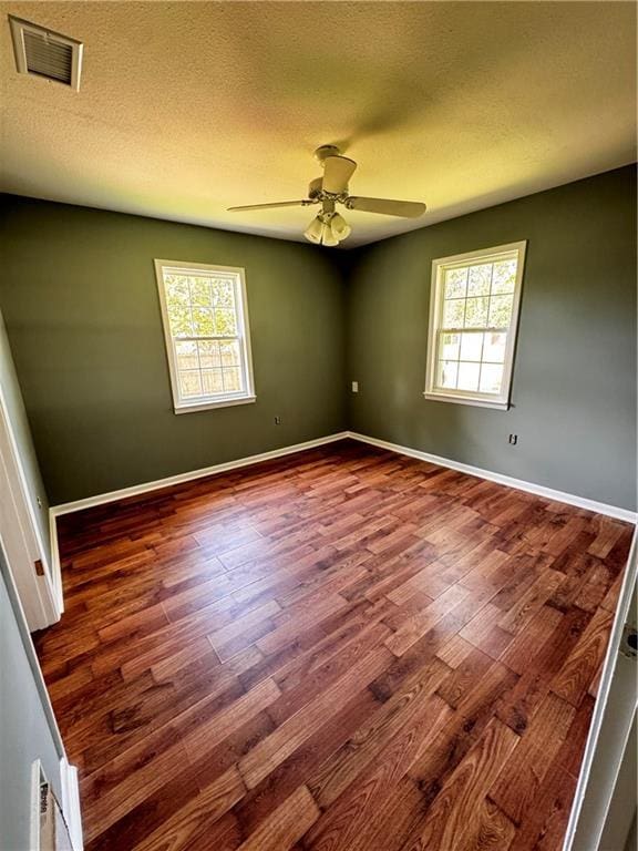 17080A Wayne Johnson Ln, Fairhope, AL 36532 - spare room featuring plenty of natural light, wood finished floors, a ceiling fan, and a textured ceiling