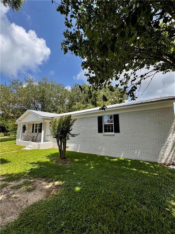 17080A Wayne Johnson Ln, Fairhope, AL 36532 - view of home's exterior featuring brick siding, a yard, and a porch