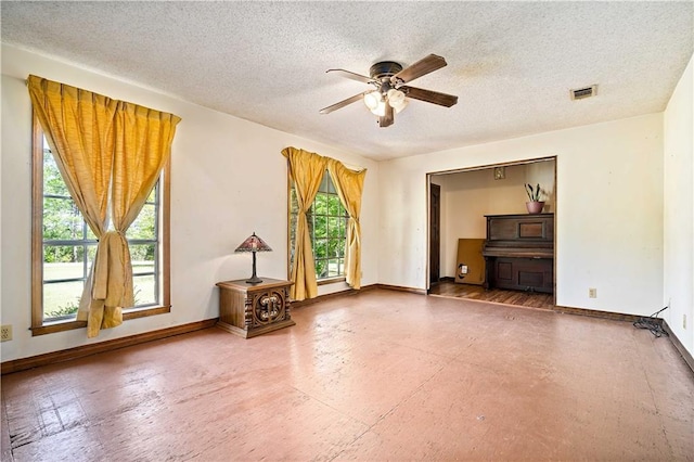 8170 Wilmer Georgetown Rd, Wilmer, AL 36587 - unfurnished living room featuring a textured ceiling, ceiling fan, visible vents, and a wealth of natural light
