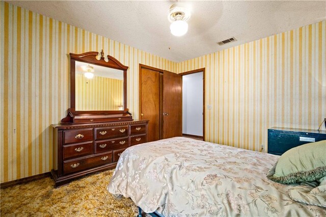 8170 Wilmer Georgetown Rd, Wilmer, AL 36587 - bedroom with a closet, carpet flooring, a textured ceiling, visible vents, and ceiling fan