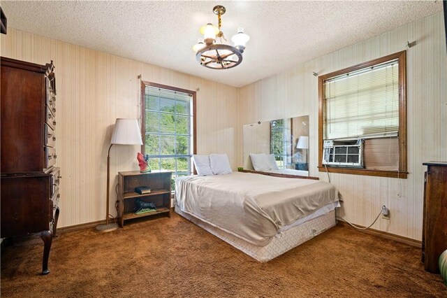 8170 Wilmer Georgetown Rd, Wilmer, AL 36587 - carpeted bedroom featuring wooden walls, cooling unit, a notable chandelier, and a textured ceiling