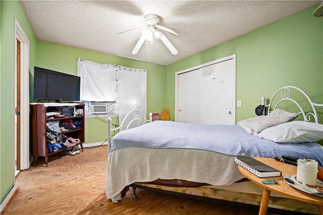 8170 Wilmer Georgetown Rd, Wilmer, AL 36587 - bedroom featuring baseboards, a closet, a textured ceiling, a ceiling fan, and wood finished floors